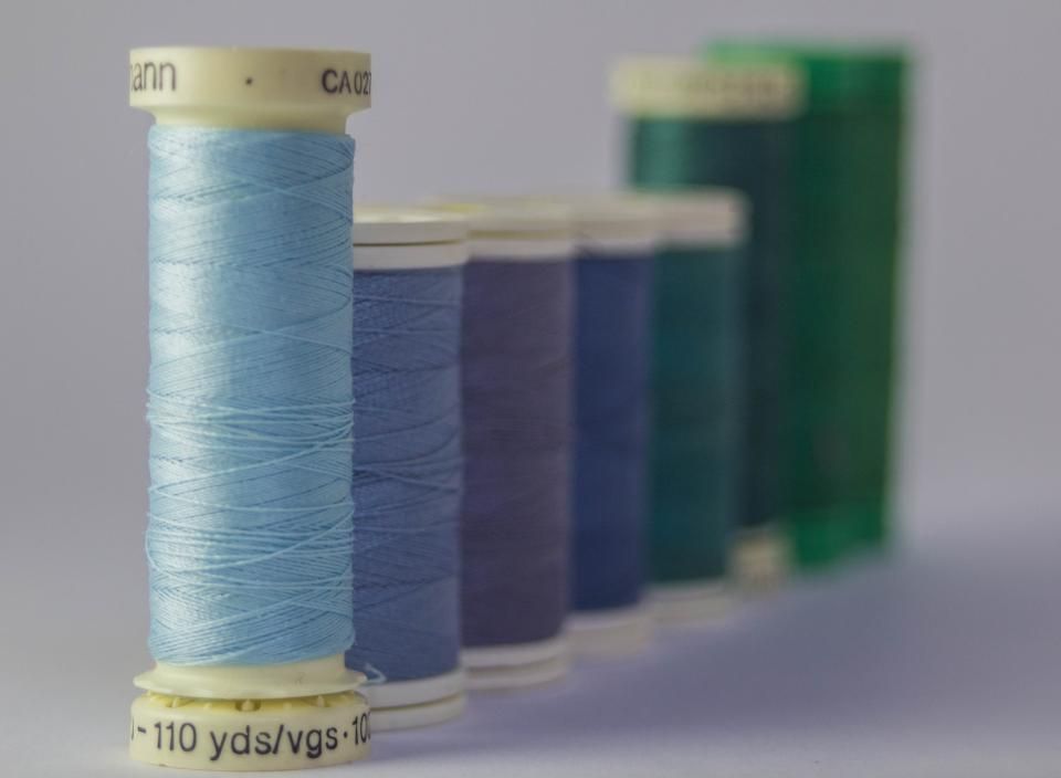 Spools of blue and green thread on a table