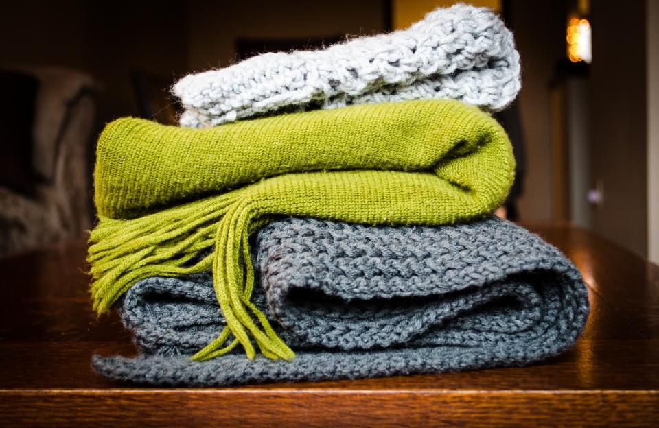 A stack of soft folded blankets in green and grey