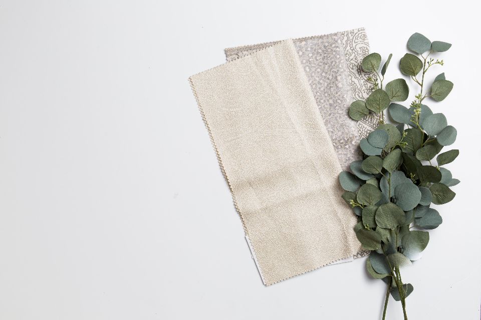 Neutral linen fabric swatches with eucalyptus leaves